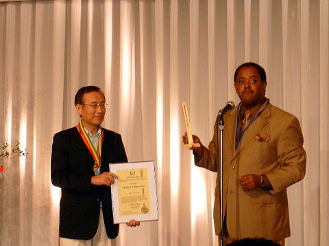 Mussie Hailu (on right) offering desktop Peace Pole